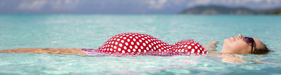 young smiling pregnant woman floating on water at the Caribbean beachview images from the same series: